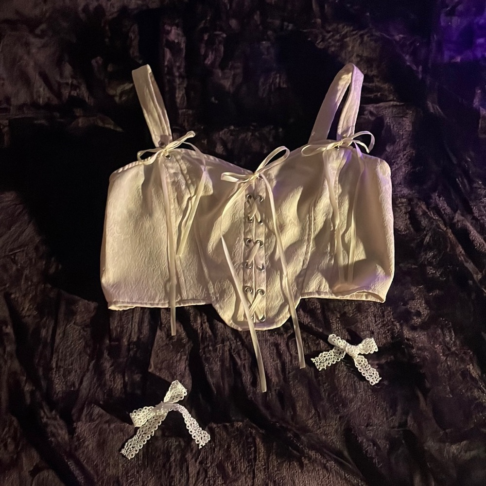 cream colored corset top, with ribbon sequence in the front